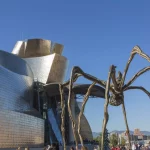 Bilbao, Spain - October 29, 2016; Back of the Guggenheim Museum, contemporary art, work of the Canadian architect Frank O. Gehry, and the sculpture of the spider of Louise Bourgeois. There  are people walking
