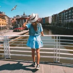 Achteraanzicht van jonge toeristische vrouw in witte zonnehoed wandelend in de stad Bilbao. Zomervakantie in Spanje. Foto van hoge kwaliteit