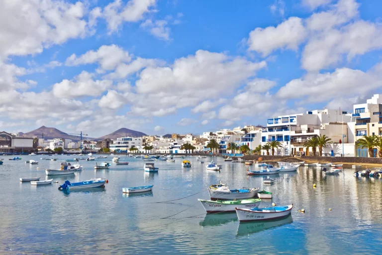 Arrecive, Spain - December 23, 2010: fisherman anchors the boat in Charco de San Gines in Arrecife, Spain. The harbor area was remodelled by Canarian architect César Manrique in 1984.