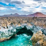 Fantastisk utsikt över lavagrottorna Los Hervideros och vulkanerna på ön Lanzarote, en populär turistattraktion. Plats: Lanzarote, Kanarieöarna, Spanien. Konstnärlig bild. Skönhet värld. Resekoncept.