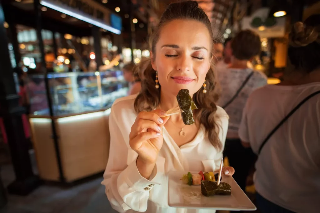 happy elegant traveller woman in white shirt at San Miguel Market enjoying tapas