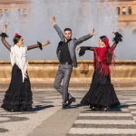 Drie mensen met flamenco-outfit dansen op het traditionele plein van Spanje in Sevilla