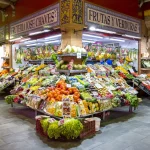 Verkopers van fruit, groente, vlees en producten en kraampjes op de kleurrijke en levendige Triana Markt of Mercado di Triana in de historische wijk Triana van de Andalusische stad Sevilla in Spanje.