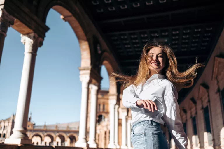 Laughing young woman enjoying sightseeing in Seville, Spain
